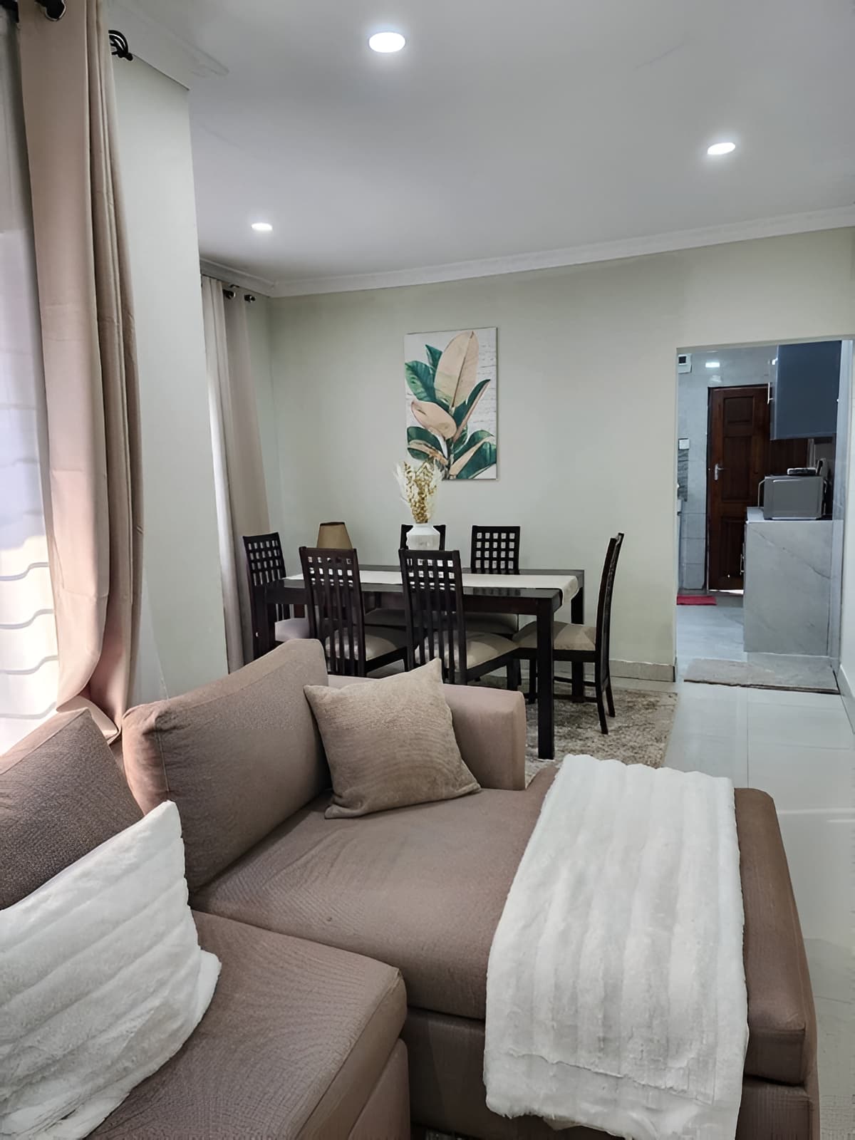 A spacious modern apartment living room with warm oak floors and city views
