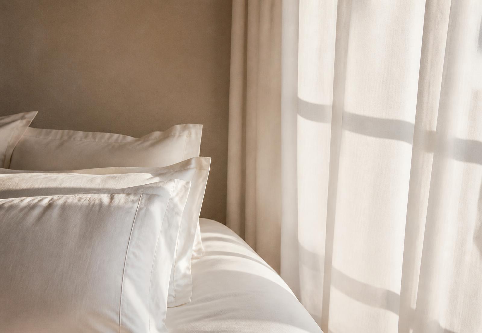 Soft morning light across crisp linen bedding